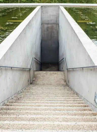 Water Temple by Tadao Ando, [lotus pond exterior / concrete wing walls / descent staircase / vermilion sanctuary interior / light court / Awaji Island hillside context], 1991 Japan
