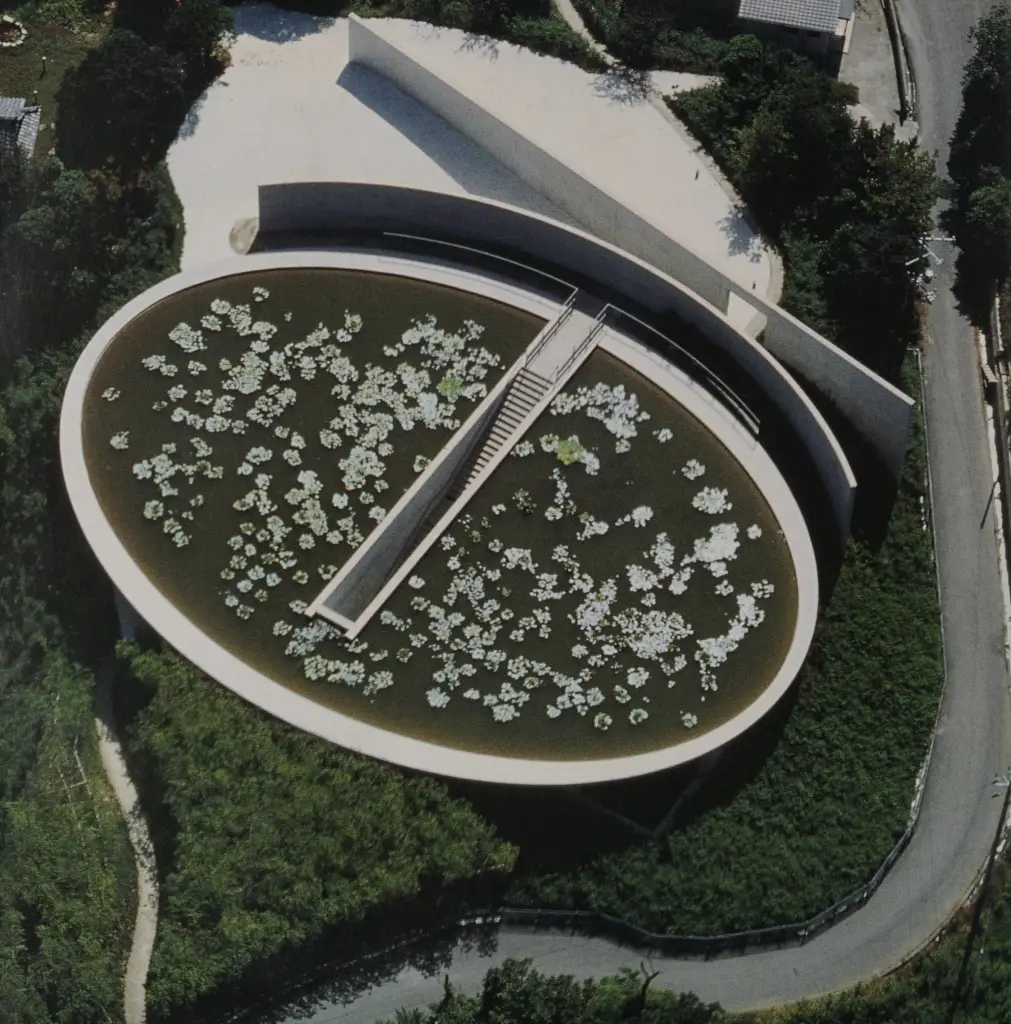 Water Temple by Tadao Ando, [lotus pond exterior / concrete wing walls / descent staircase / vermilion sanctuary interior / light court / Awaji Island hillside context], 1991 Japan