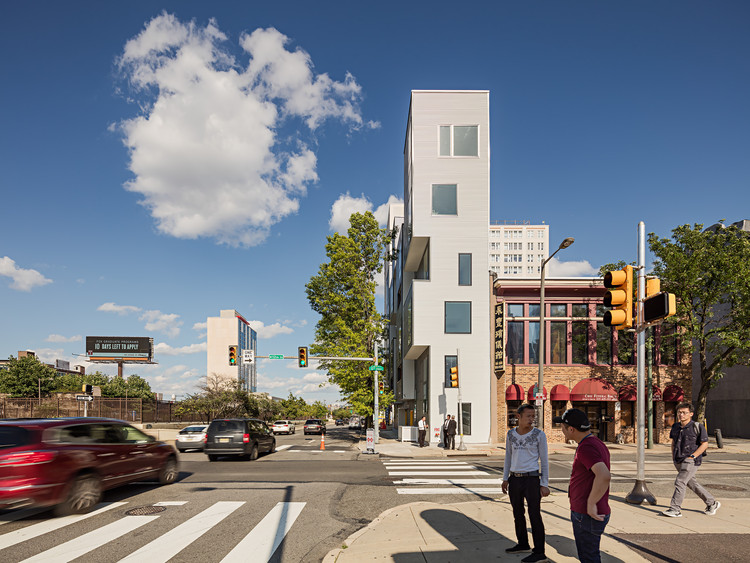 XS House Philadelphia by ISA Interface Studio Architects, [exterior black fiber cement facade / mezzanine interior / narrow site plan / street-level unit entry / bi-level duplex stair / facade projection bay detail / Vine Street Expressway context / building section diagram], 2019
